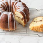 Butter cake with chocolate filling and white icing glaze, sliced to show moist interior with chocolate swirls, on cooling rack, delicious homemade dessert, perfect for celebrations and tea time.