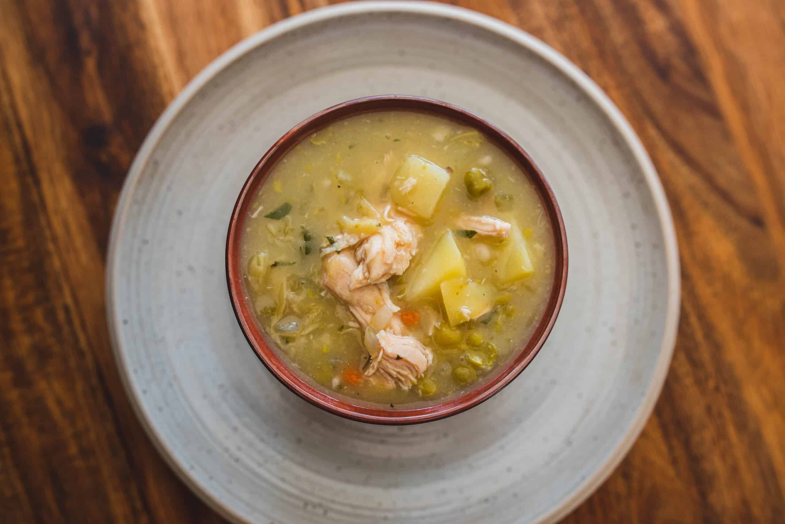 Creamy chicken vegetable soup with potatoes, peas, and shredded chicken served in a bowl. Perfect comfort food for cold days, easy to prepare, and packed with nutritious ingredients.