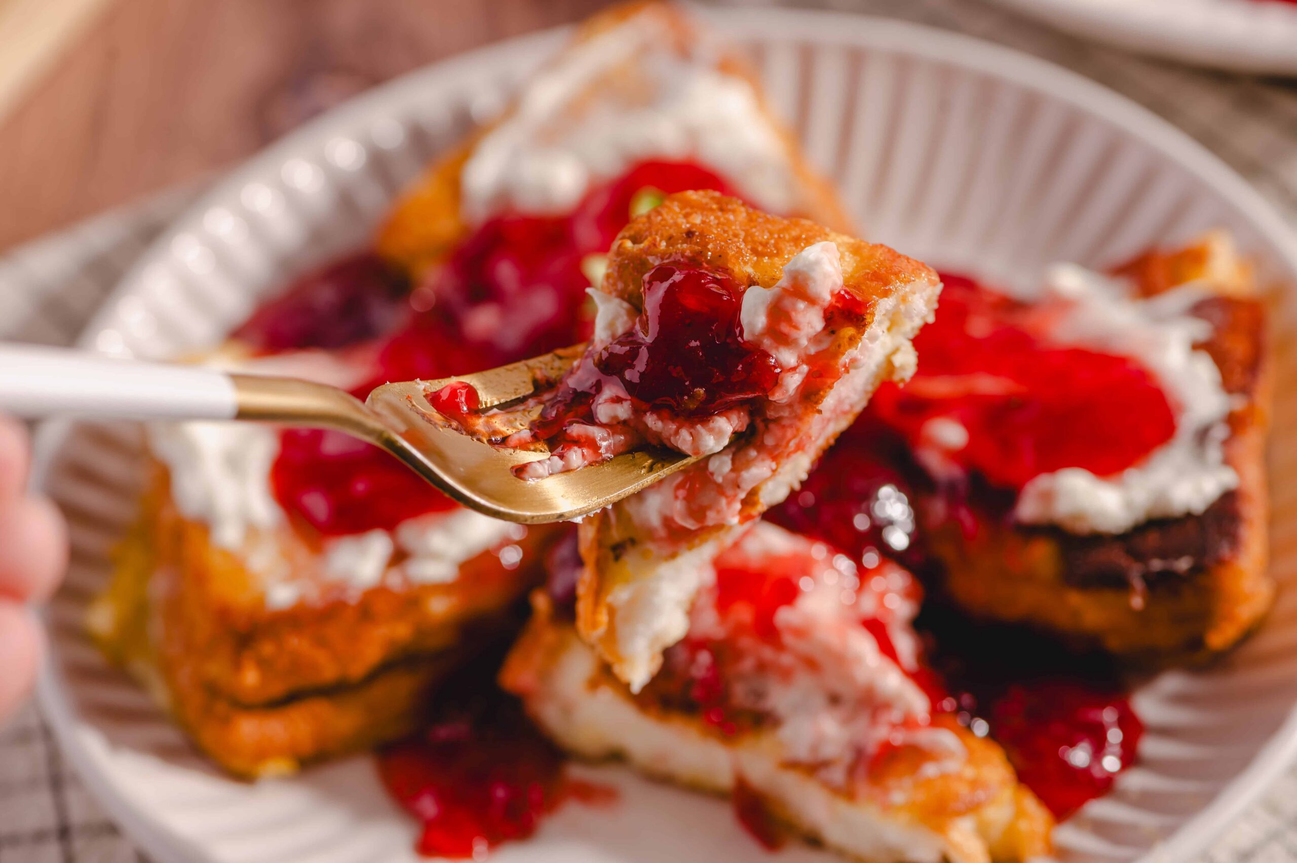 Sweet potato casserole with cranberry sauce and marshmallows on a paper plate, close-up of a fork taking a bite, highlighting the creamy texture and vibrant berry topping, perfect for holiday desserts.