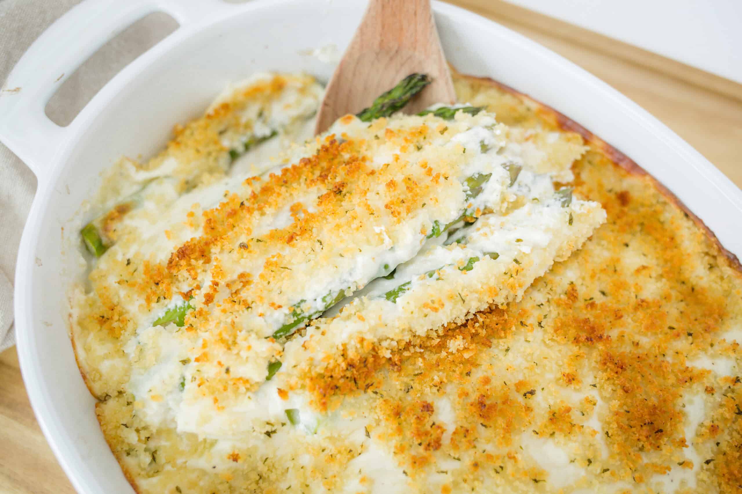 Crispy baked creamy casserole with green beans, topped with golden breadcrumbs and cheese, served in a white baking dish, perfect for hearty homemade comfort food.