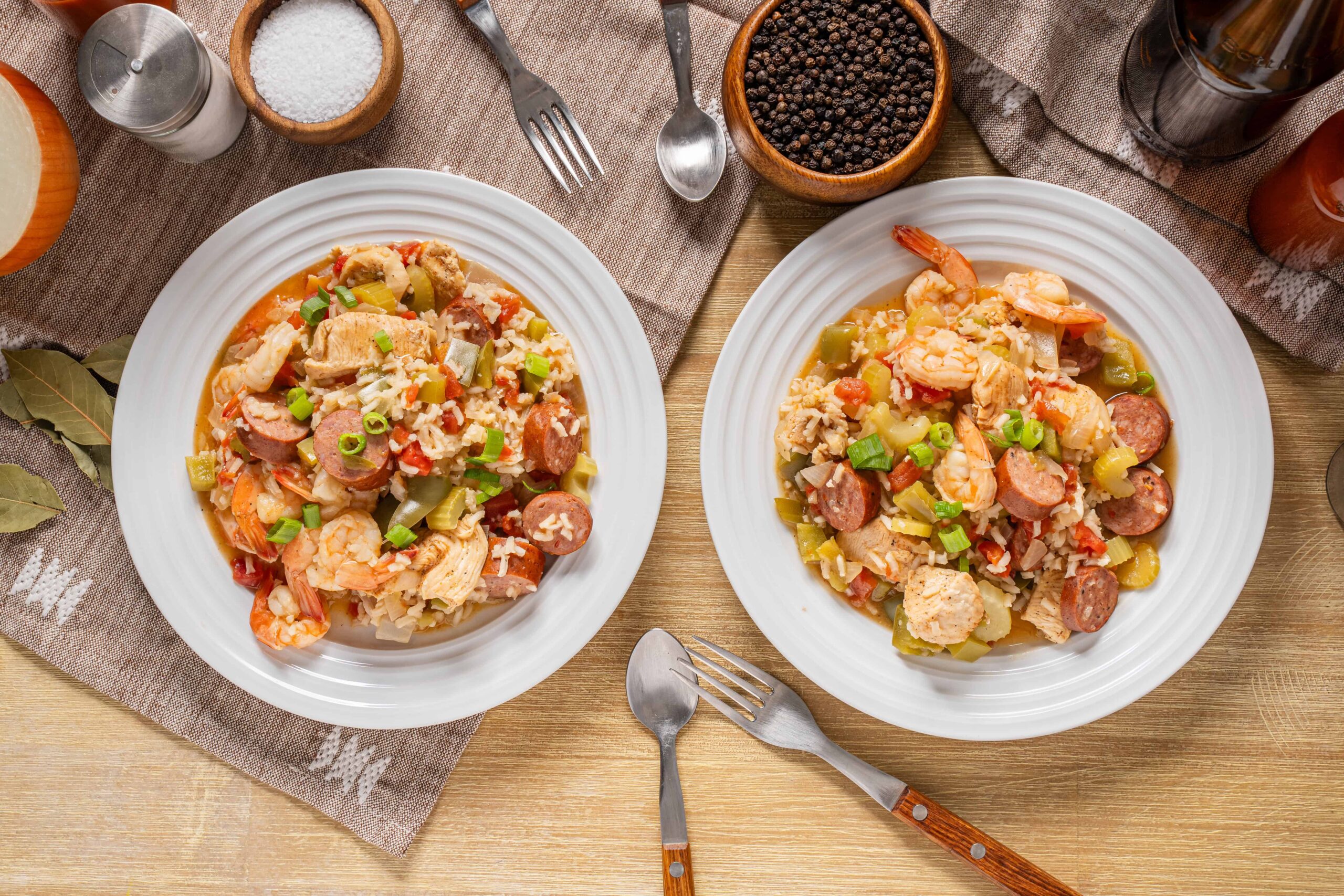 Savory shrimp and sausage fried rice with vegetables served on white plates for a hearty meal.