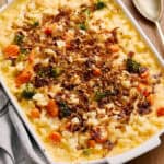 Creamy chicken and vegetable casserole topped with crispy fried onions in a white baking dish. Perfect comfort food with tender chicken, broccoli, carrots, and pasta, baked to golden perfection.
