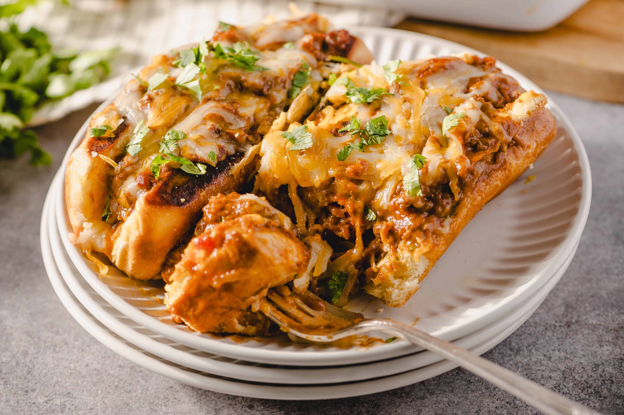 Delicious beef and cheese stuffed enchiladas with melted cheese and fresh cilantro on a white plate.
