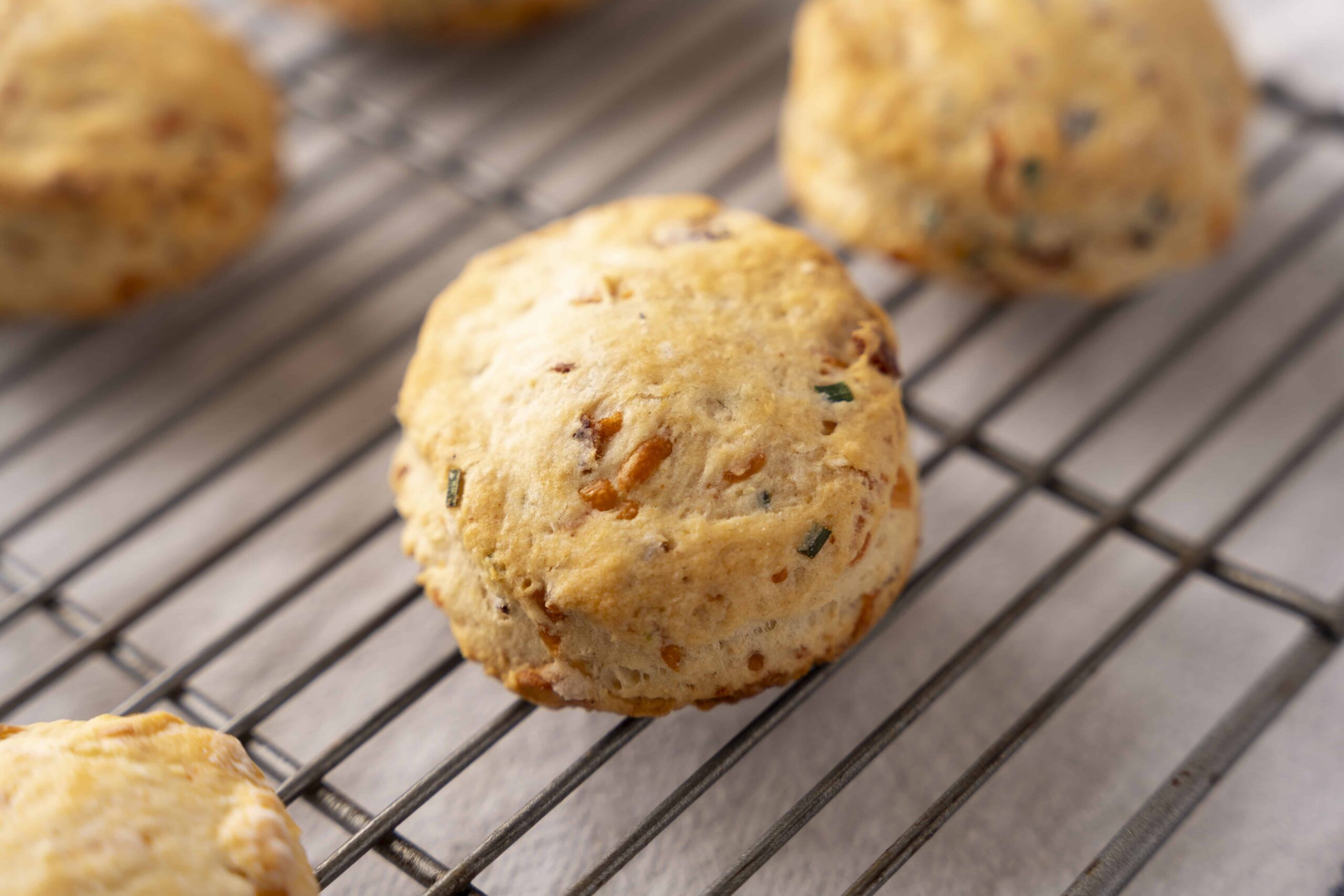 Crab meat and chives biscuits on cooling rack, fresh baked seafood biscuits, savory crab and chives biscuits for appetizers, crispy and golden seafood biscuits, homemade crab and chives seafood biscuits, relevance.