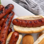 Grilled sausages on bread buns, hot dog sandwiches, barbecue-style hot dogs, tasty sausages with grill marks, casual outdoor food, popular American hot dog filling, delicious grilled meats, easy summer party food, savory meat sandwiches, classic hot dog recipe.