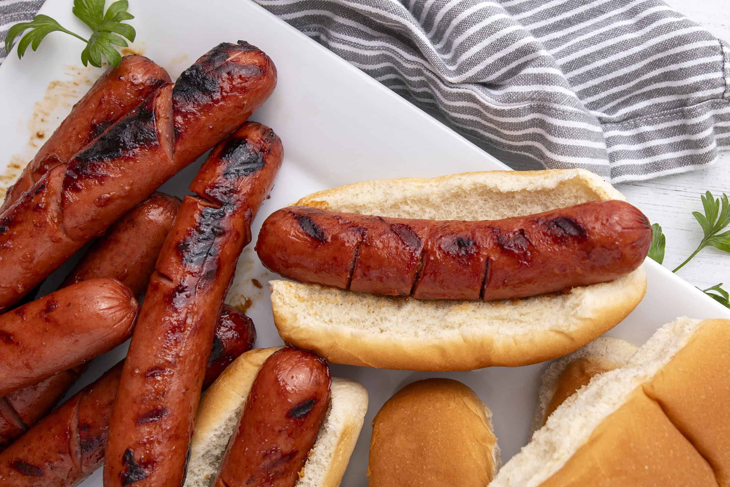 Grilled sausages on bread buns, hot dog sandwiches, barbecue-style hot dogs, tasty sausages with grill marks, casual outdoor food, popular American hot dog filling, delicious grilled meats, easy summer party food, savory meat sandwiches, classic hot dog recipe.