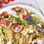 Fresh garden salad with cherry tomatoes, crispy bacon, blue cheese, and creamy dressing, served on a white plate, ideal for healthy eating, summer meals, or easy lunch recipes.