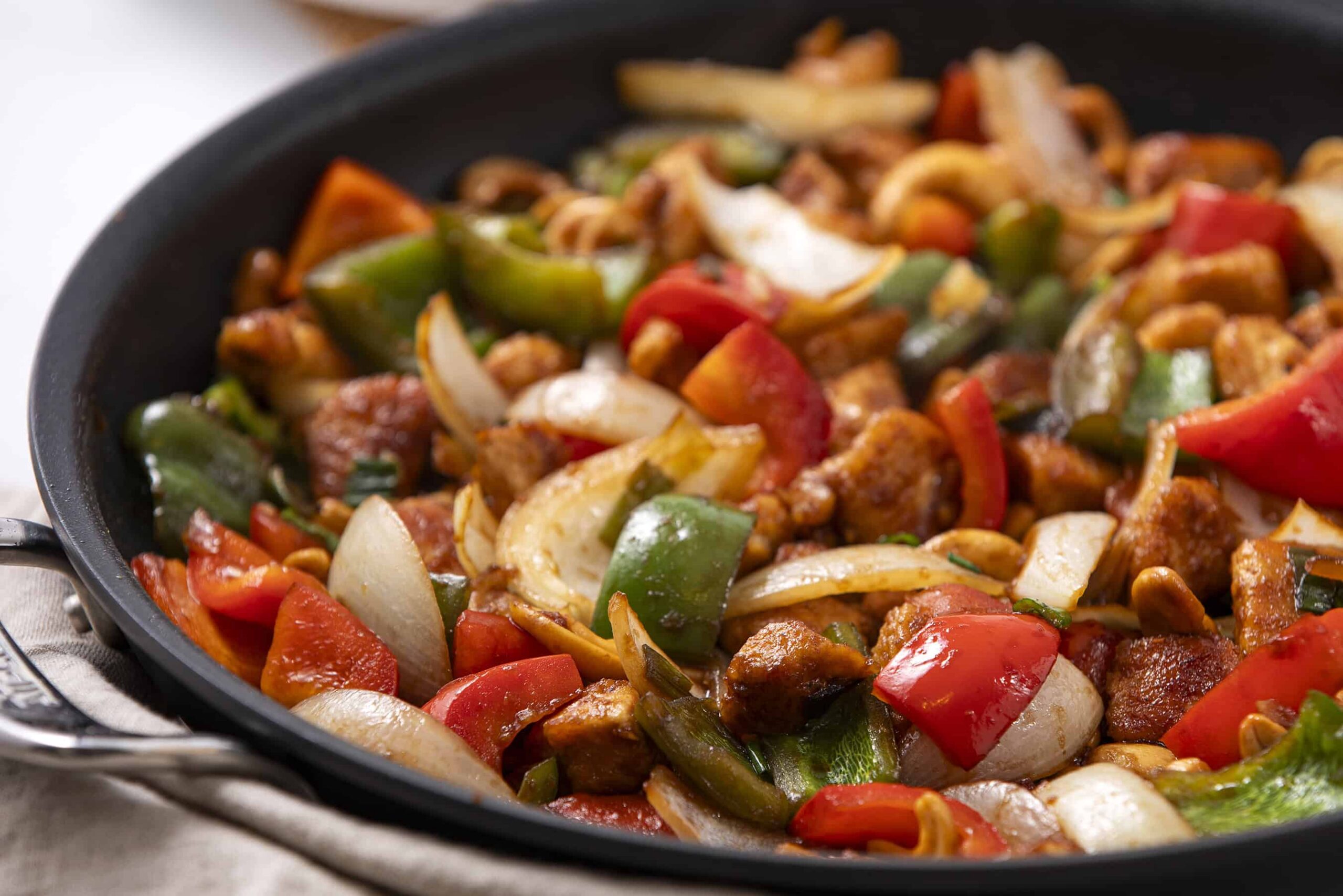 Sautéed vegetable and chicken stir-fry in a black skillet, featuring colorful bell peppers, onions, and tender chicken pieces, perfect for healthy dinner recipes.