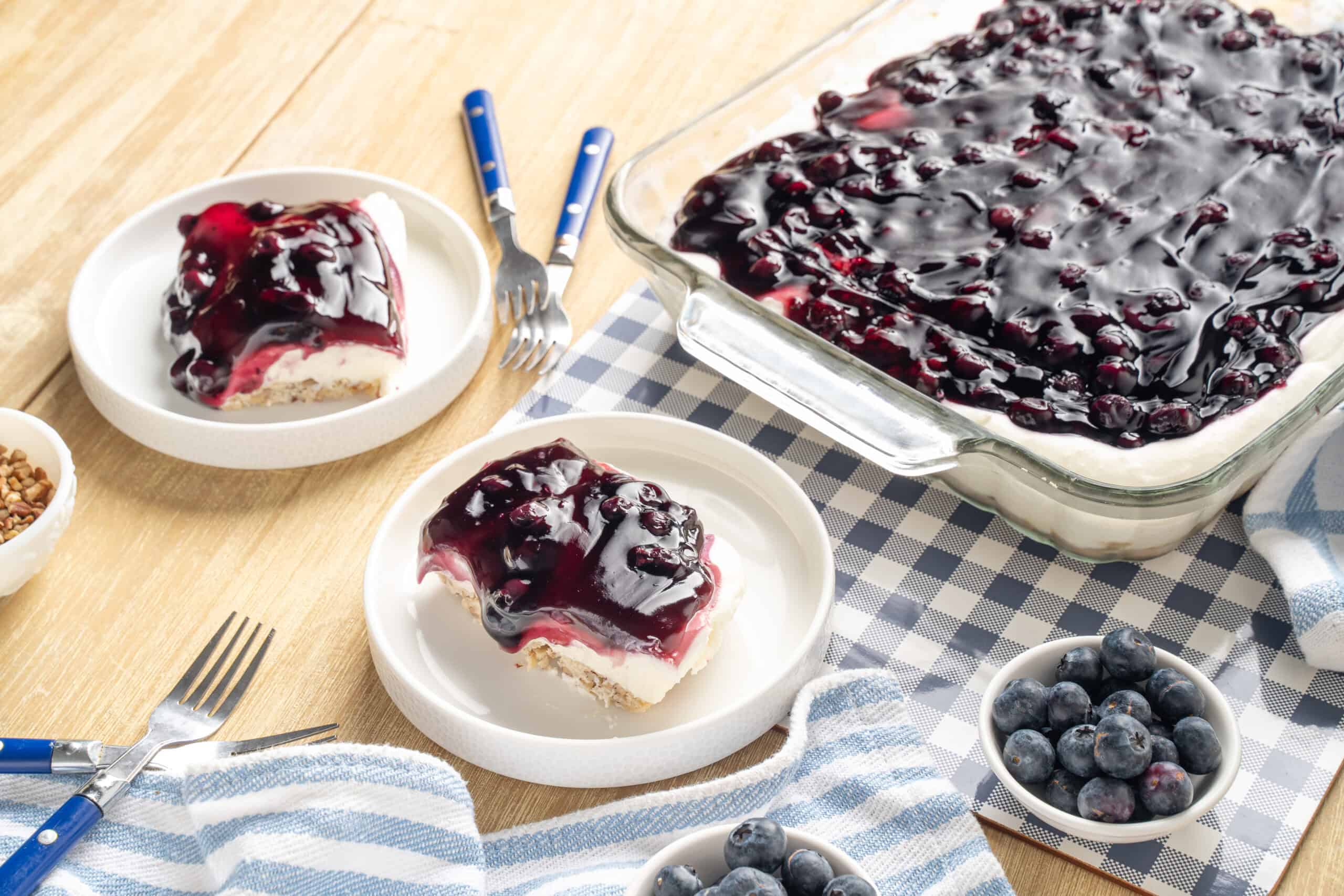 Sweet blueberry cheesecake dessert with fresh blueberries on top, served in white ramekins on a wooden table, perfect for summer dessert recipes and healthy snack options.