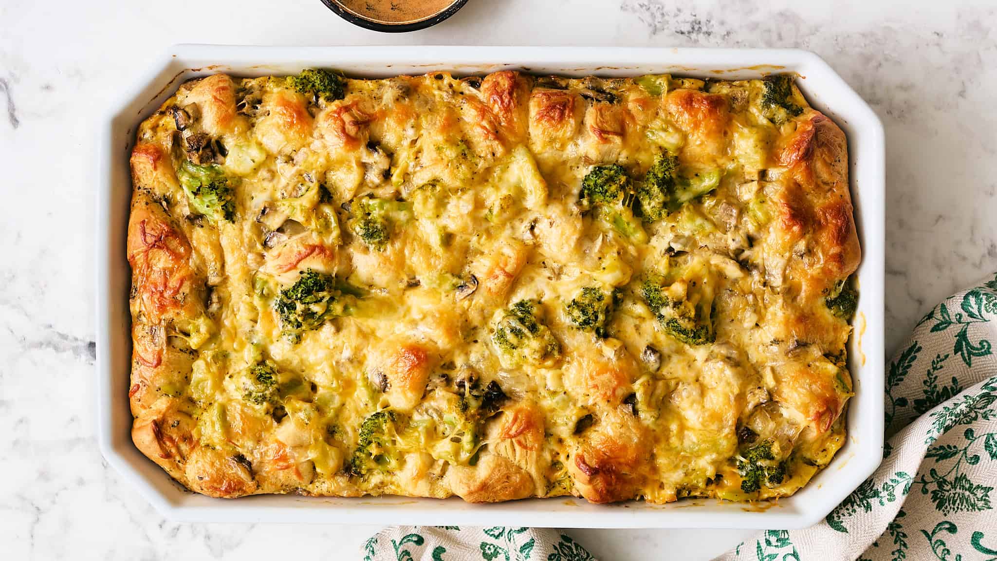 Creamy broccoli and mushroom casserole baked with cheese in a white dish, served as a delicious comfort food or family dinner. Perfect for vegetable lovers and easy to prepare.