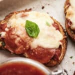 Savory baked bread topped with tomato sauce, melted cheese, and fresh basil leaves, perfect for homemade pizza or Italian-inspired appetizers.