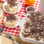 Creamy vanilla dessert with chocolate chips on top served in a baking dish and individual plates, perfect for baking and dessert recipes.