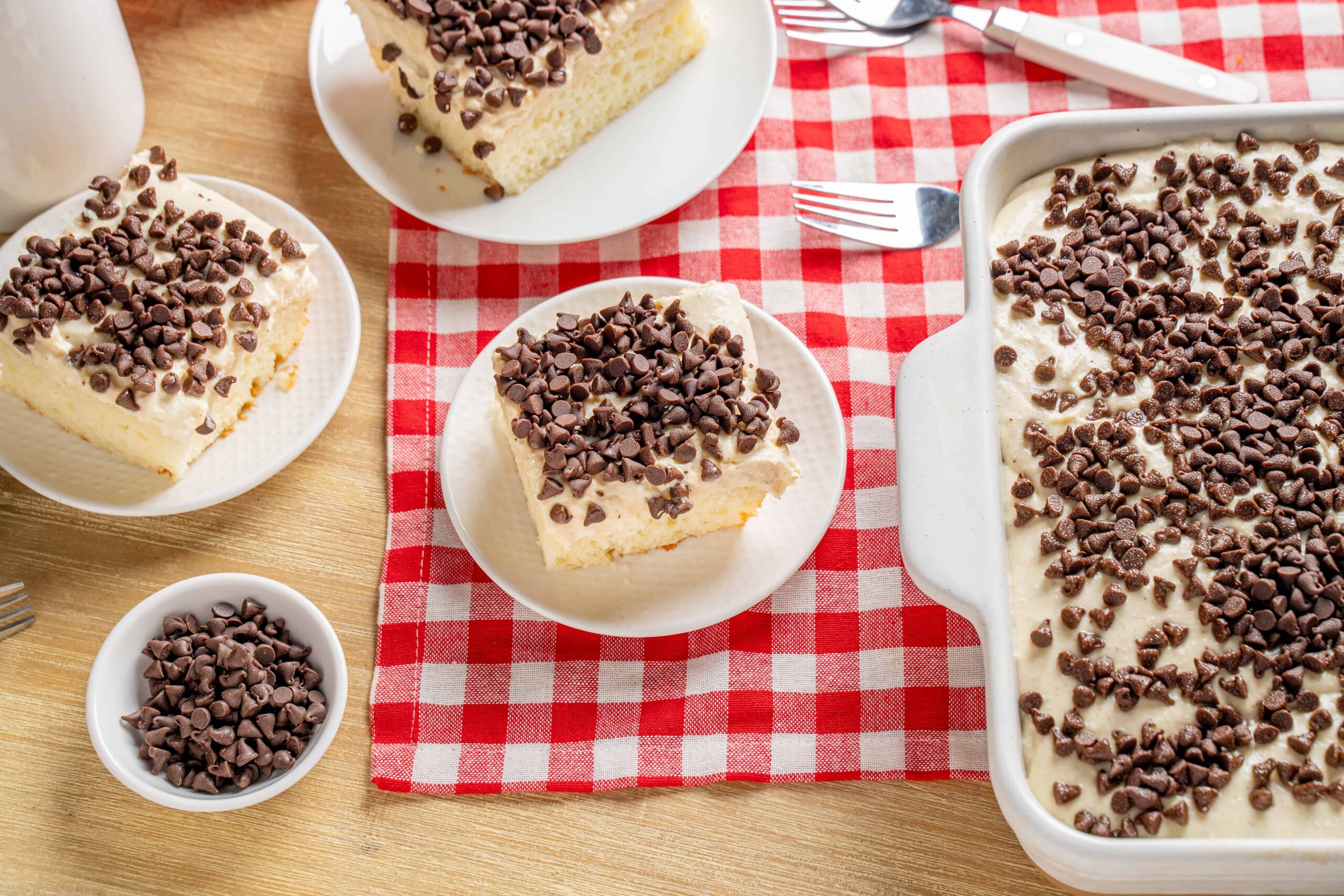 Creamy vanilla dessert with chocolate chips on top, served in slices on a white plate, ideal for dessert recipes and gatherings.