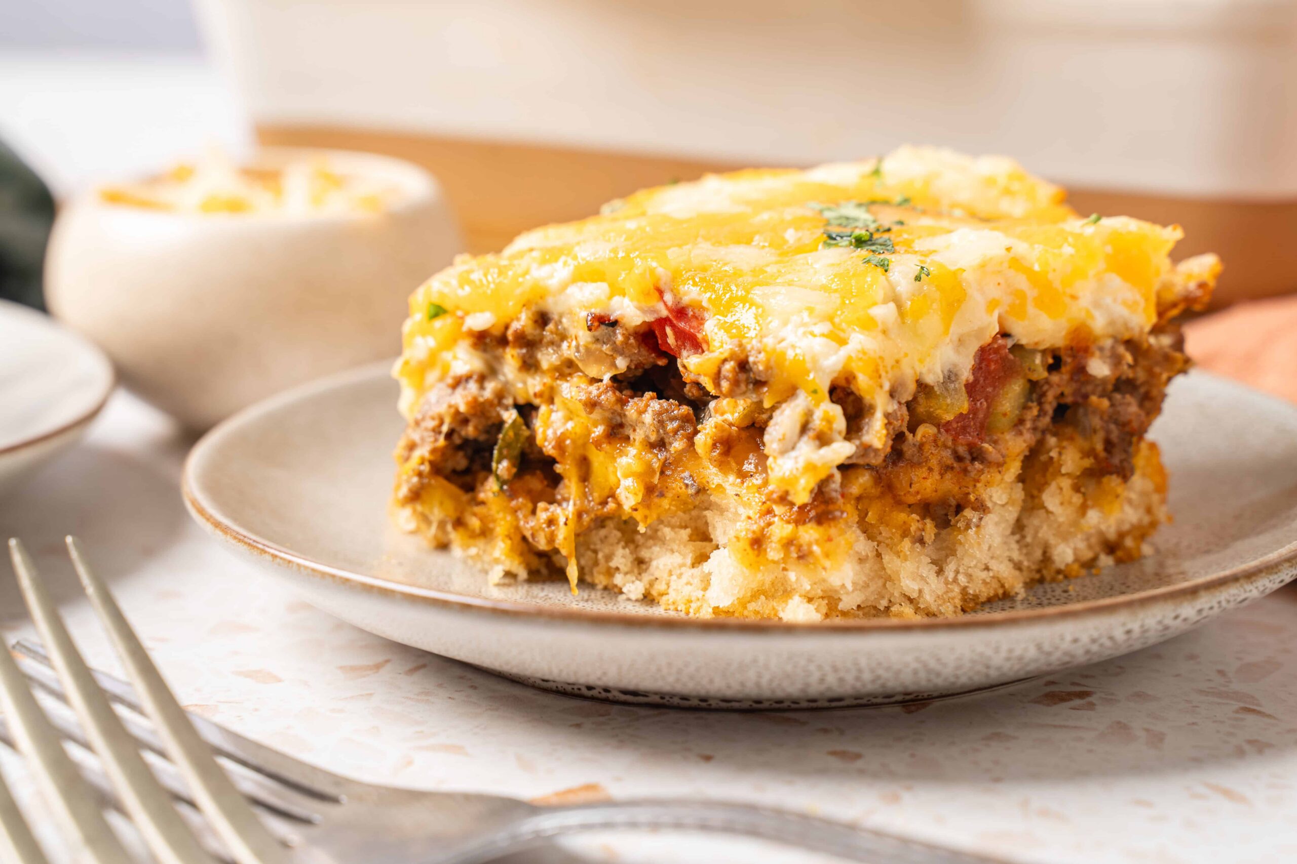 Savory beef and potato casserole with melted cheese on top, served on a beige plate, ready to enjoy a comforting homemade meal, close-up of a delicious classic dish from Hey Recipe.
