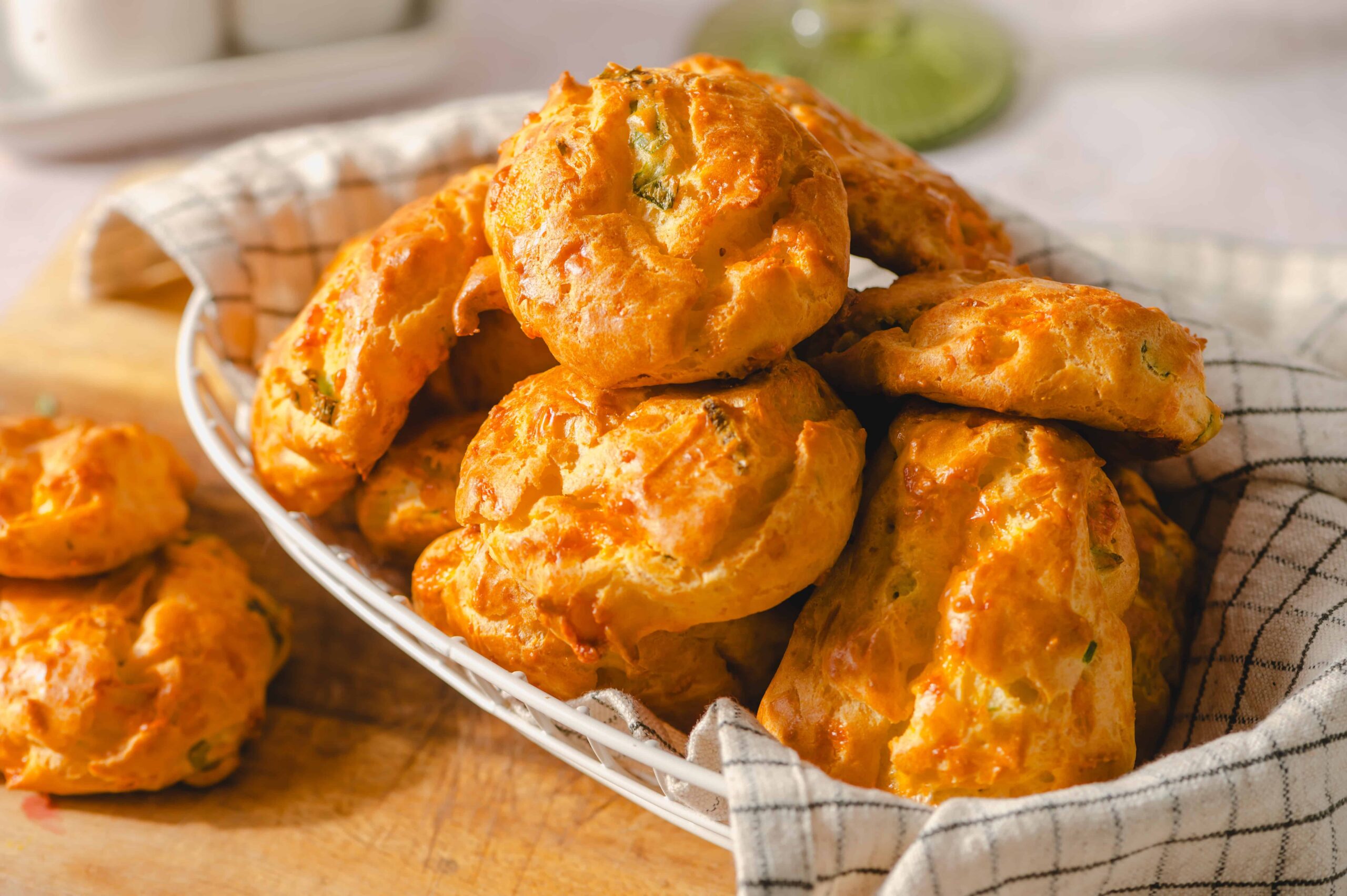 Golden cheesy crab cakes served hot on a woven basket with a checkered cloth, perfect for appetizers or snacks.