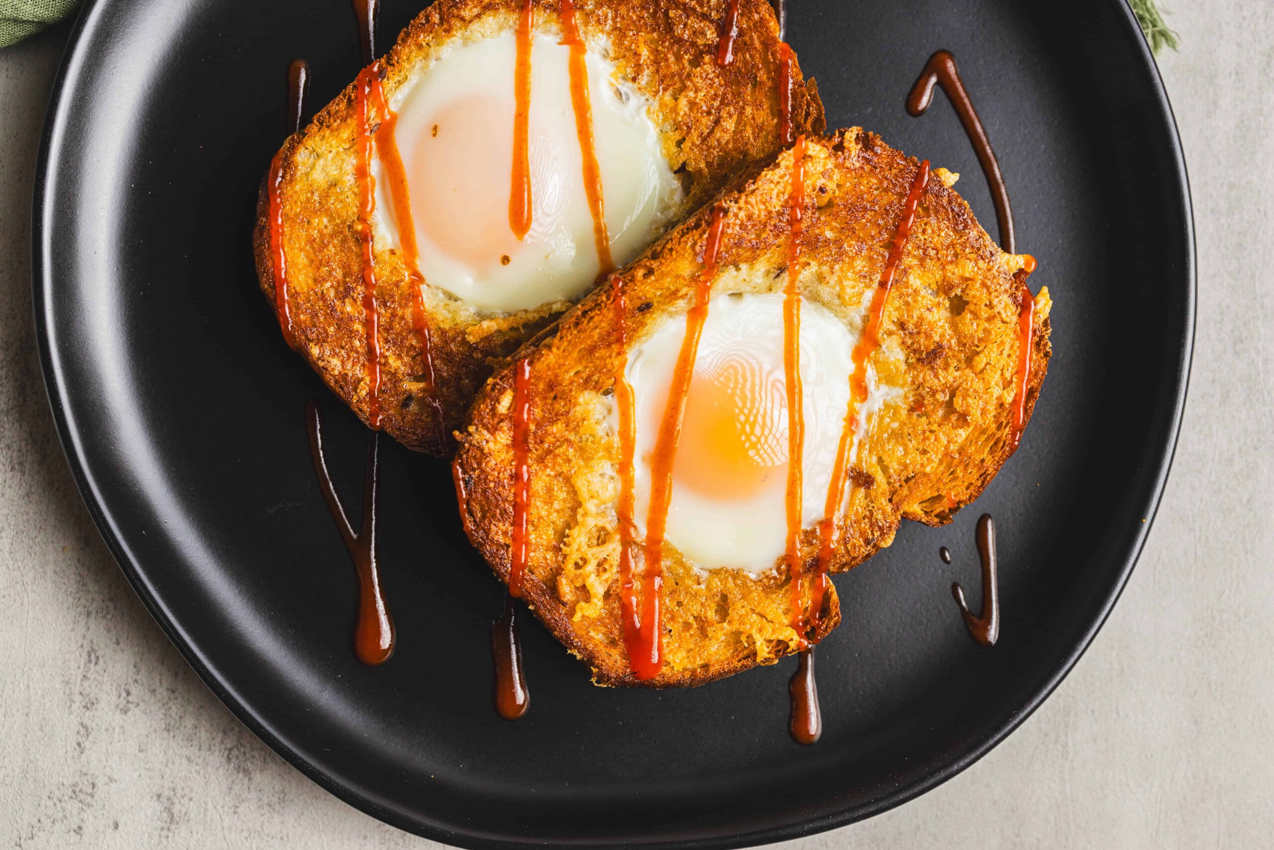 Fried eggs in potato cakes with ketchup drizzle on black plate, delicious breakfast or brunch dish, crispy potato scones with soft eggs, perfect comfort food, hearty and flavorful recipe, easy to assemble.