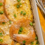 Delicious baked lemon chicken casserole garnished with chopped green onions and grated cheese, served in a white dish, perfect for family dinners and comfort food recipes.