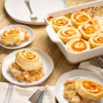 Savory chicken and vegetable stuffed roll-ups served with creamy sauce on a white plate.