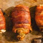 Juicy bacon-wrapped chicken drumsticks on a baking sheet, crispy and flavorful, perfect for delicious dinner recipes.