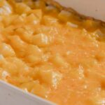 Creamy homemade breakfast casserole with melted cheese and diced potatoes in a white baking dish. Perfect for easy brunch or comfort food meals.