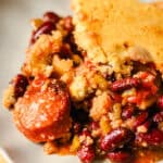 Hearty homemade chicken pot pie with crust, served with a flavorful side of seasoned beans and vegetables, making a comfort food meal perfect for family dinners.