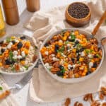 Golden beet and nut salad with dried fruits and fresh herbs in a rustic kitchen setting.