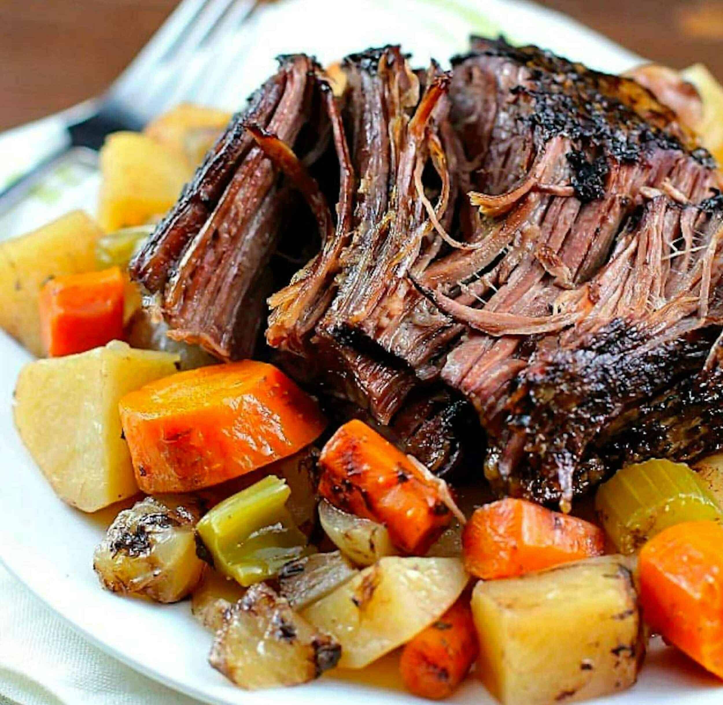 Succulent braised short ribs with roasted vegetables on white plate, perfectly cooked, tender meat, hearty comfort food, classic beef rib dish, rich flavors, appealing presentation for dinner or special occasions.