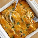 Creamy chicken casserole with melted cheese and herbs in a white baking dish, easy family-friendly dinner recipe.