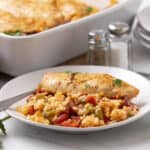 Grilled chicken breast served with flavorful vegetable rice and a side of baked casserole, perfect for a healthy and satisfying meal.