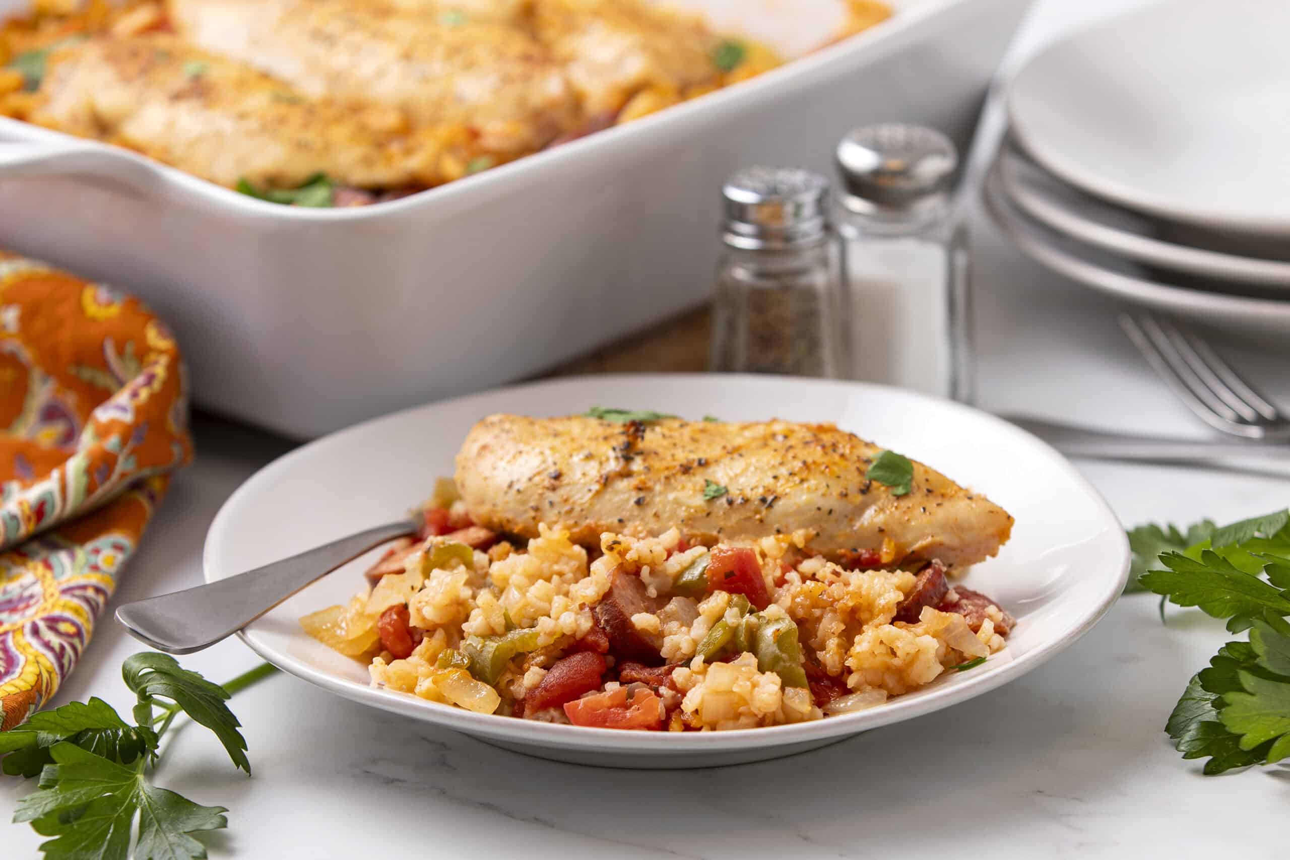 Grilled chicken breast served with flavorful vegetable rice and a side of baked casserole, perfect for a healthy and satisfying meal.