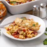 Juicy baked chicken breast served over flavorful rice and vegetable medley, perfect for a healthy and satisfying meal. Fresh herbs and colorful ingredients create an appetizing and nutritious dinner option.