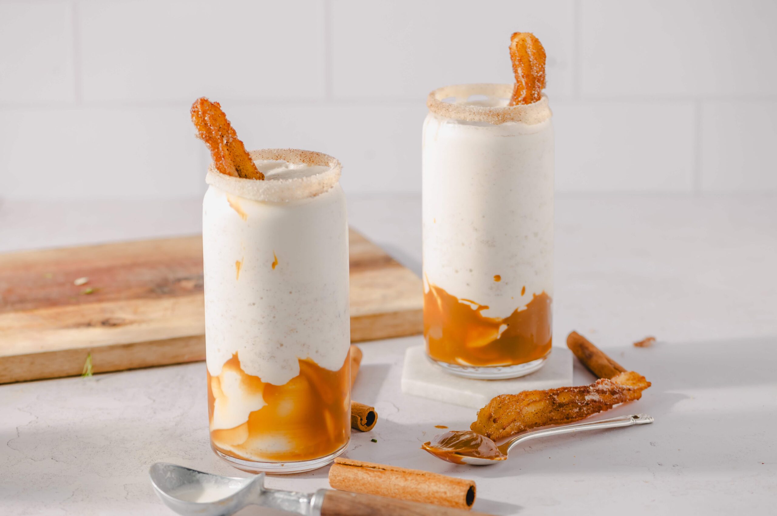 Creamy cinnamon sugar churro milkshakes with caramel drizzle and churro garnish, perfect for dessert or special occasions. Easy recipe idea from Hey Recipe for delicious treats.