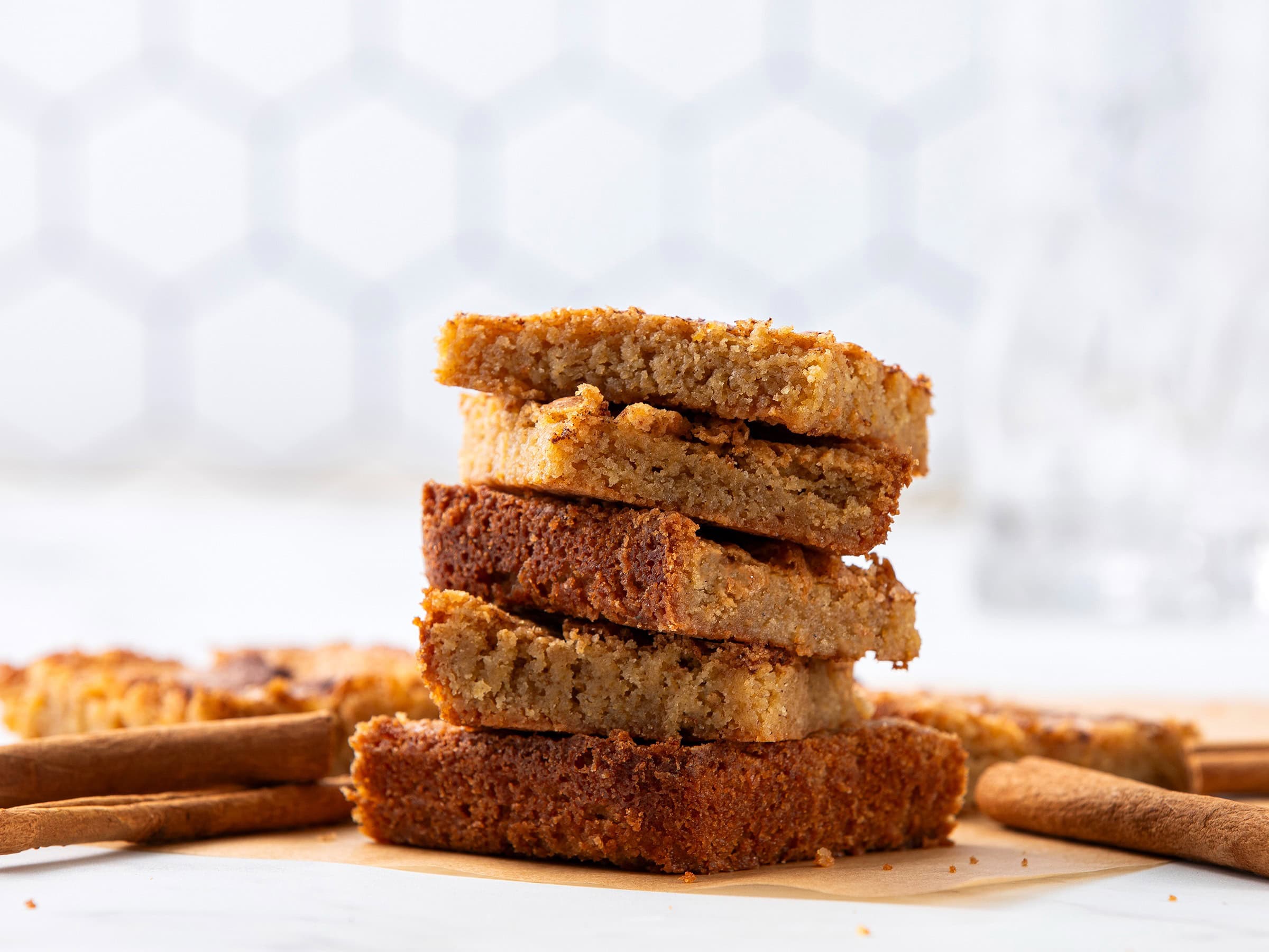 Cookies stacked on a wooden surface, showcasing different flavors and textures, with a white background and cinnamon sticks, perfect for easy homemade cookie recipes and baking ideas.