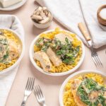 Creamy mushroom and spinach chicken served over pasta in bowl for easy weeknight dinner.