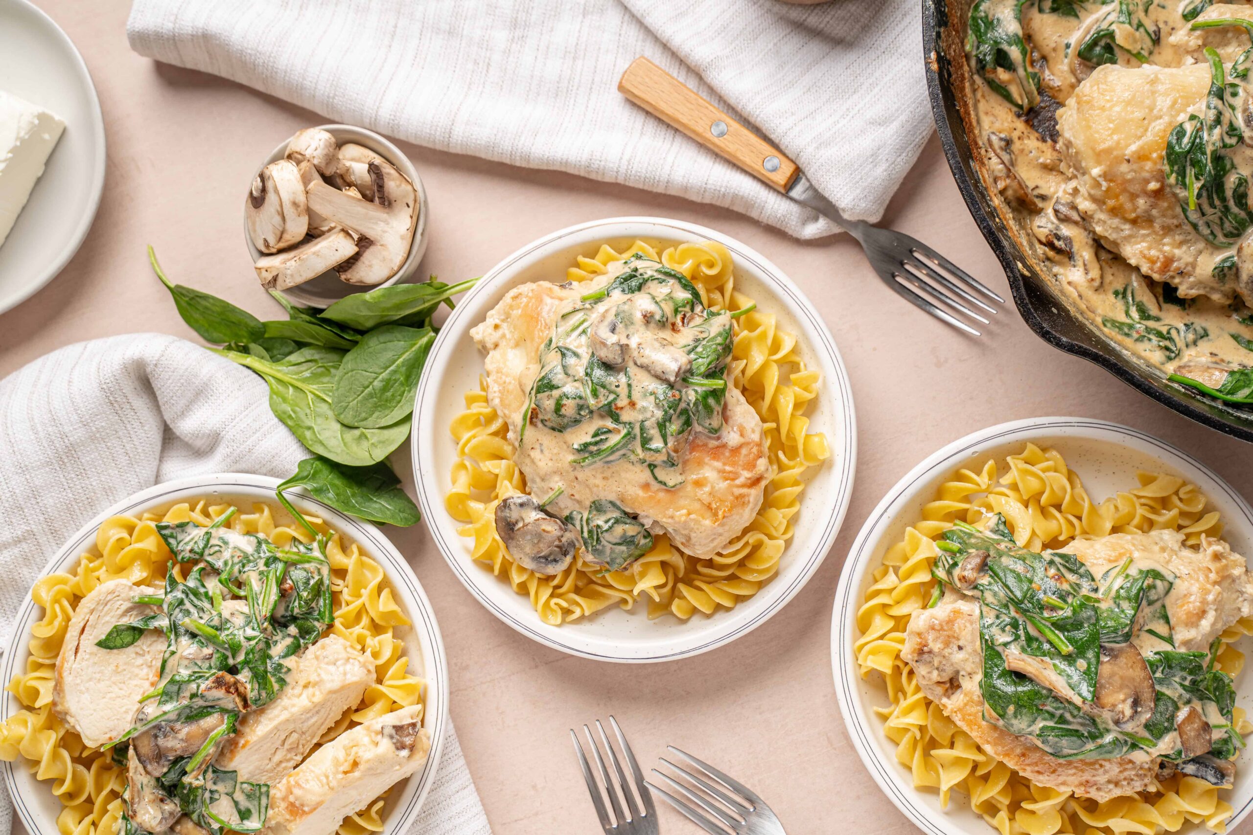 Creamy mushroom and spinach chicken breast served over egg noodles with fresh herbs and a mushroom sauce.