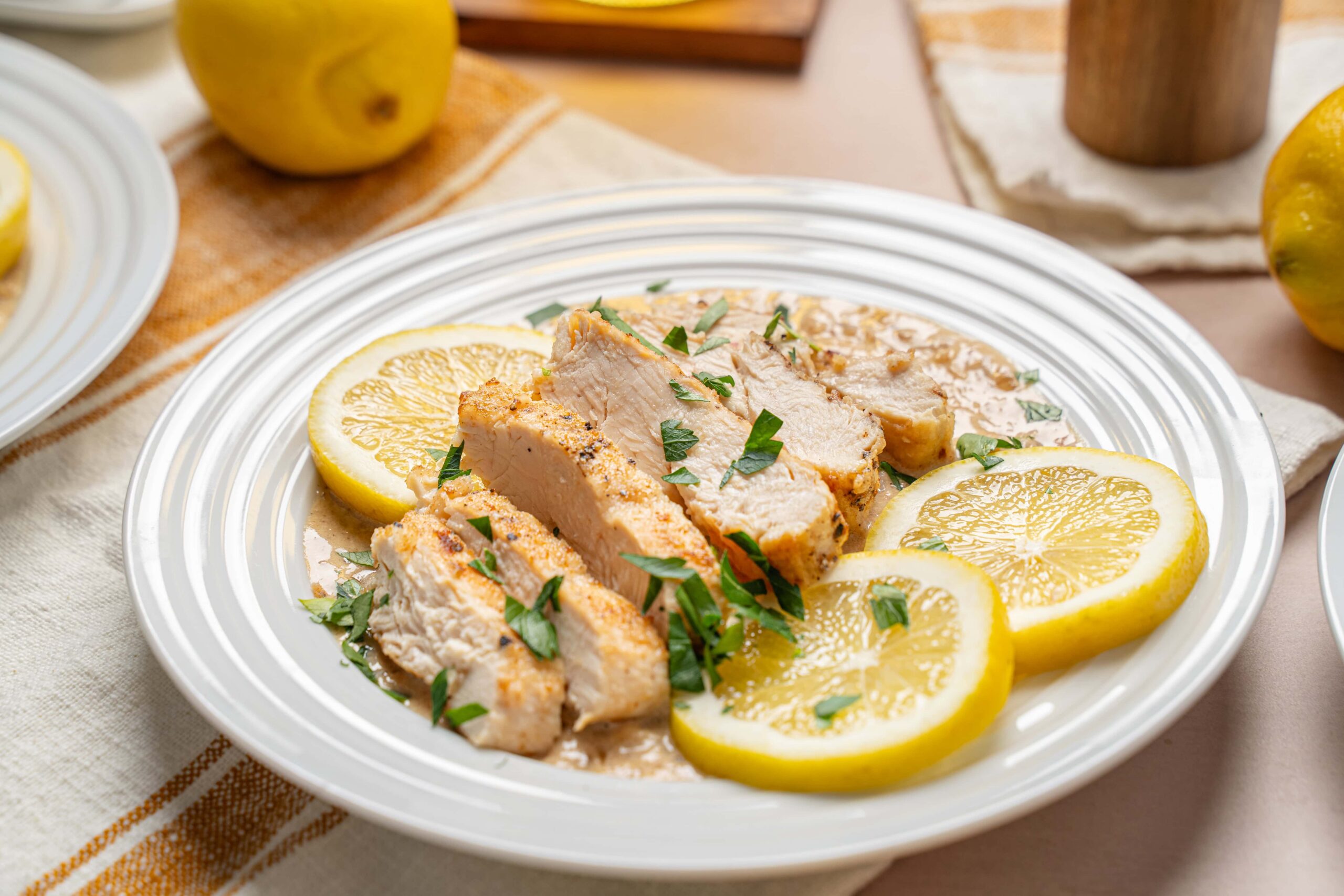 Juicy lemon herb chicken breast garnished with fresh parsley, served on a white plate with lemon slices for a flavorful, healthy meal.
