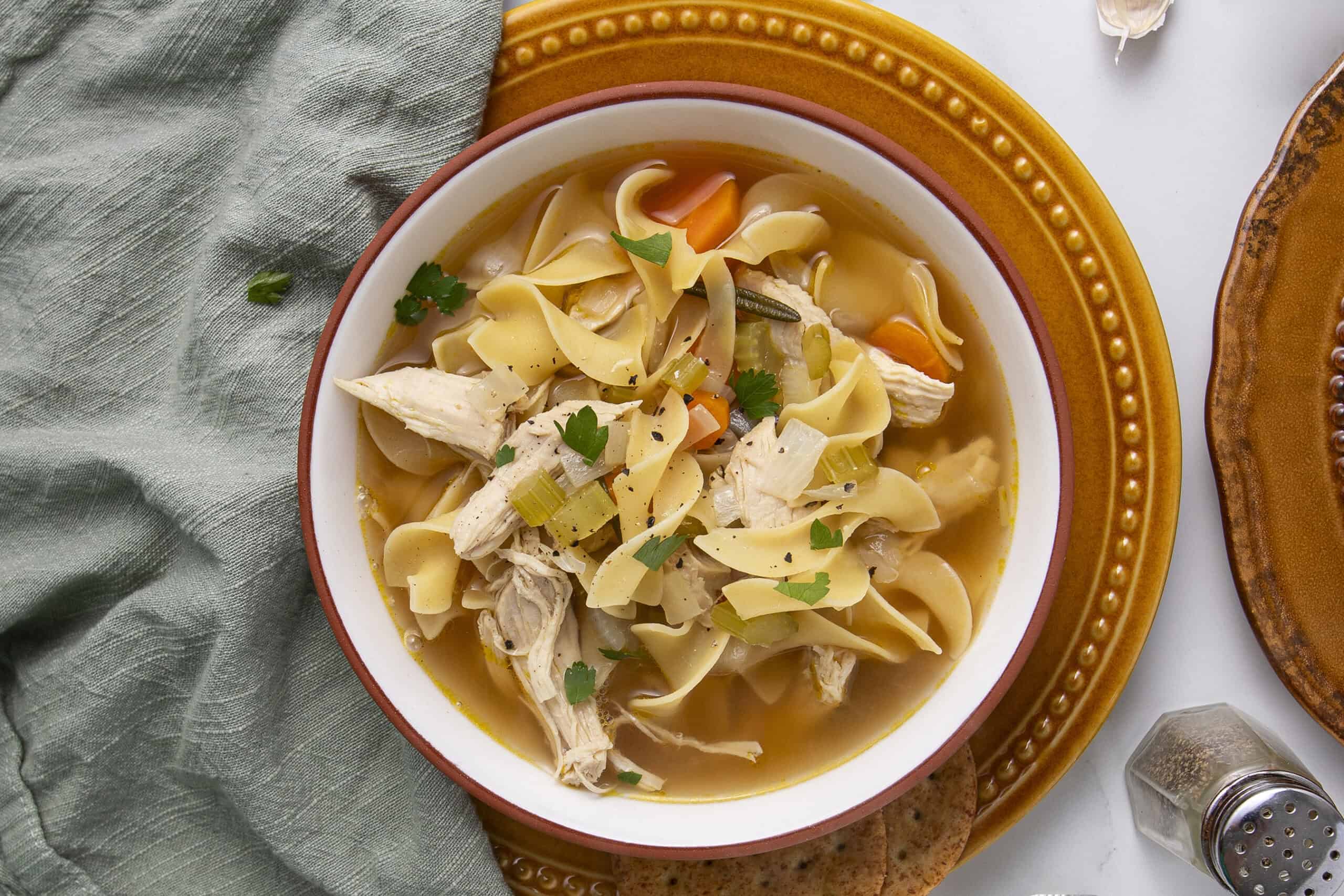 Comforting chicken noodle soup with tender shredded chicken, egg noodles, carrots, celery, and parsley in a clear broth. Perfect for cozy meals and cold days, easy homemade soup recipe from Hey Recipe.