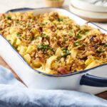 Savory baked pasta casserole with ground meat, cheese, and herbs in a white and blue baking dish for a comforting meal.