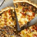 Flavorful homemade pizza slices topped with melted cheese, red peppers, and savory meat, fresh from the oven. Perfect for a quick dinner or snack, showcasing a crispy crust and delicious toppings.