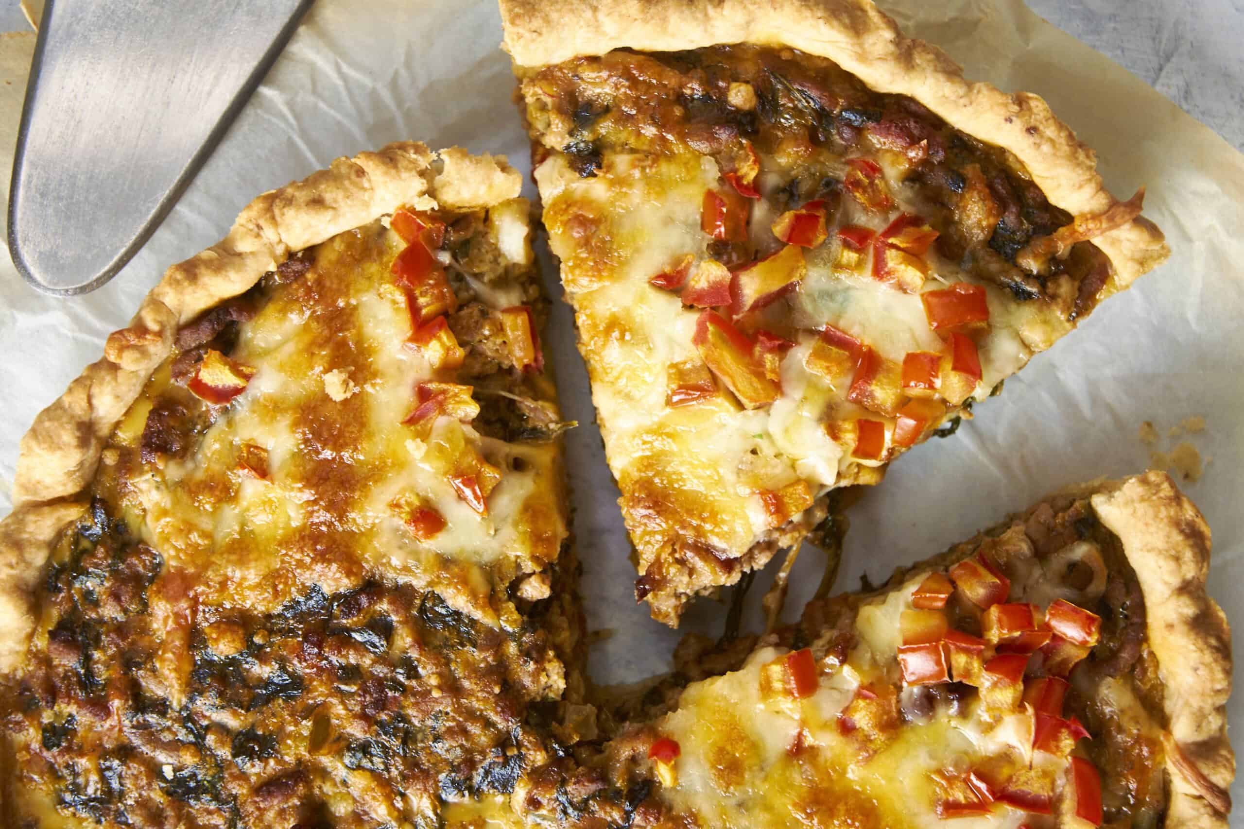 Flavorful homemade pizza slices topped with melted cheese, red peppers, and savory meat, fresh from the oven. Perfect for a quick dinner or snack, showcasing a crispy crust and delicious toppings.