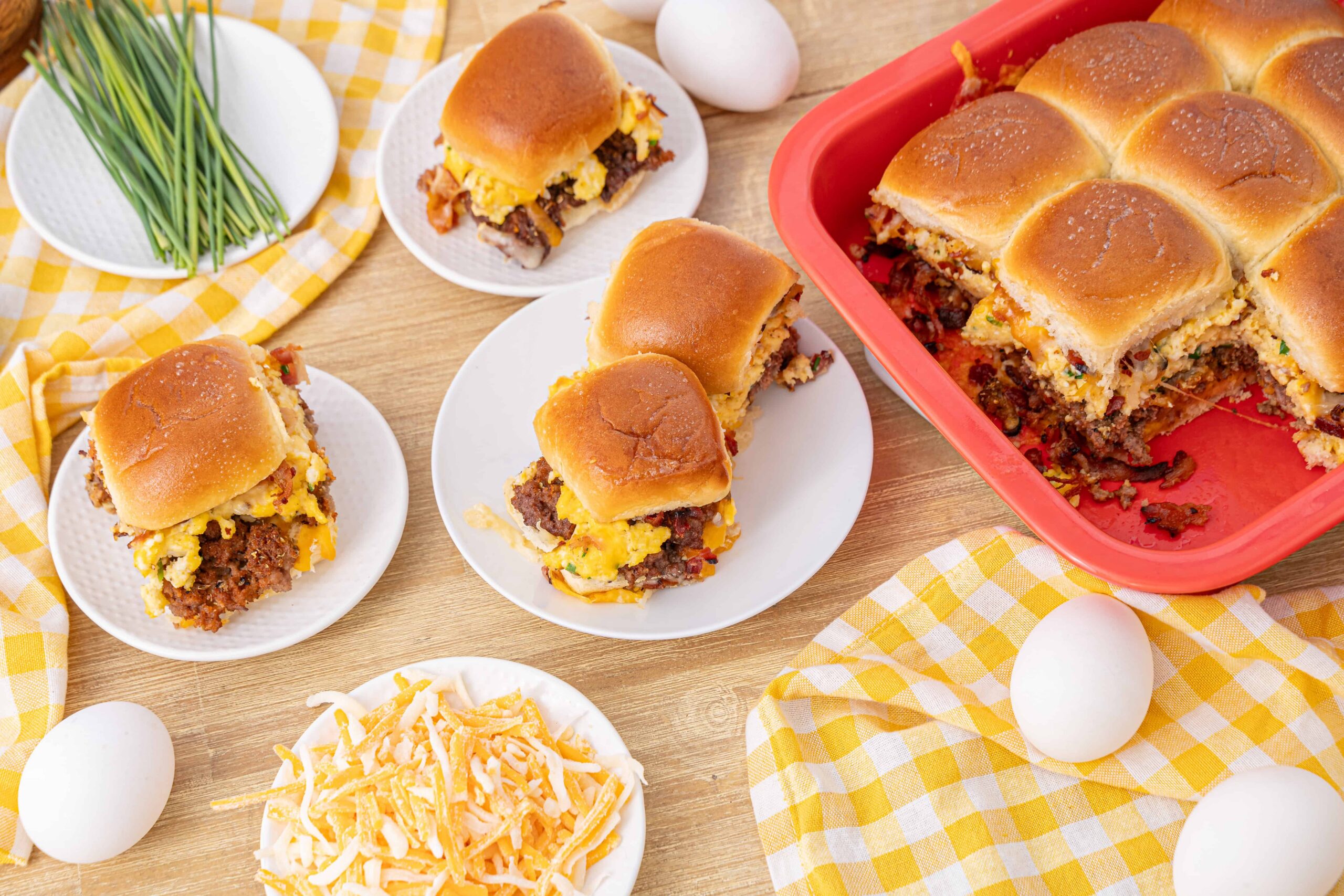 Creamy breakfast casserole with sausage, eggs, cheese, and biscuit topping on a wooden table.