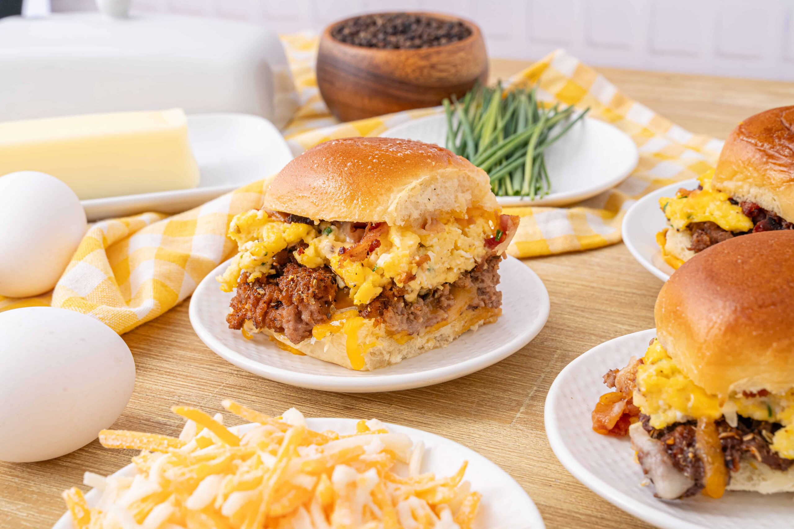 Scrambled egg breakfast sliders with ground beef and cheese on a white plate, cozy breakfast scene, hearty breakfast sandwich with eggs and meat, delicious brunch idea for morning meal, Hey Recipe.