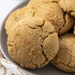 Butterscotch cookies on a white plate with a textured cloth background, showcasing the crumbly, golden-brown exterior and rich flavor. Perfect for baking and sweet treats, ideal for cookie lovers and dessert recipes.