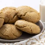 Soft, buttery peanut butter cookies on a gray plate with a glass of milk in the background, perfect for snack or dessert. Homemade cookies with a golden, crisp exterior and chewy center, ideal for peanut butter lovers.