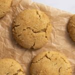 Soft, crinkly Biscoff cookies with a golden-brown crumbly texture, arranged on crumpled parchment paper for a delicious, homemade cookie presentation. Perfect for cookie lovers and baking enthusiasts.
