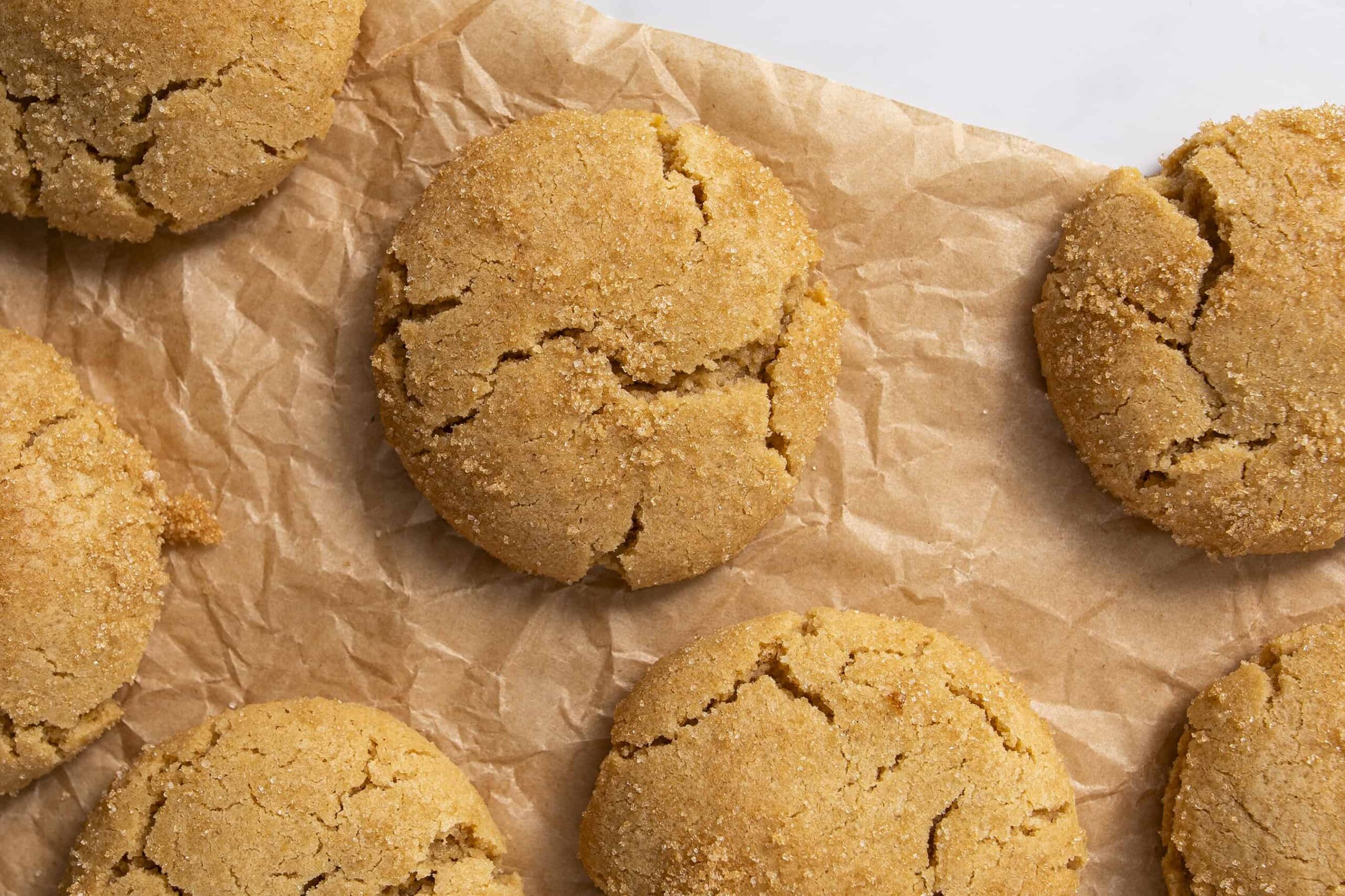 Soft, crinkly Biscoff cookies with a golden-brown crumbly texture, arranged on crumpled parchment paper for a delicious, homemade cookie presentation. Perfect for cookie lovers and baking enthusiasts.