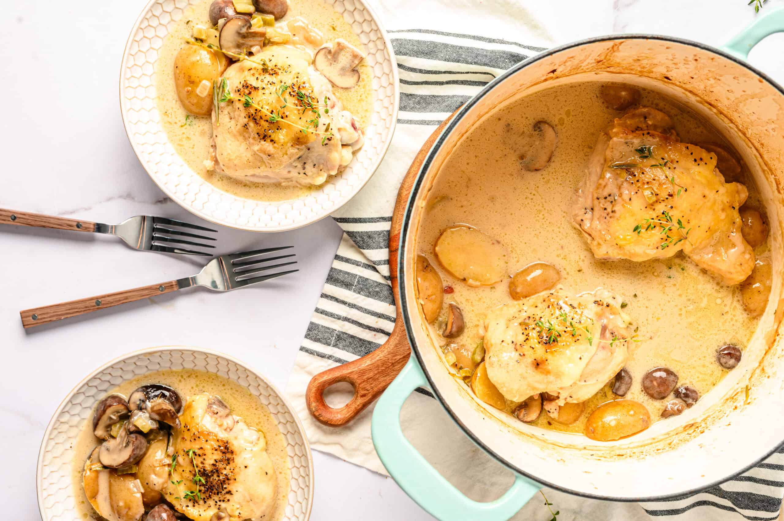Juicy chicken thighs cooked in a creamy mushroom sauce with garlic, thyme, and potatoes, served with fresh herbs. Perfect comfort food recipe for dinner or special occasions.