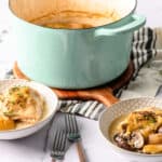 Creamy chicken and mushroom stew served with tender chicken, fresh mushrooms, and potatoes in a flavorful broth, garnished with herbs, in a cozy kitchen setting.