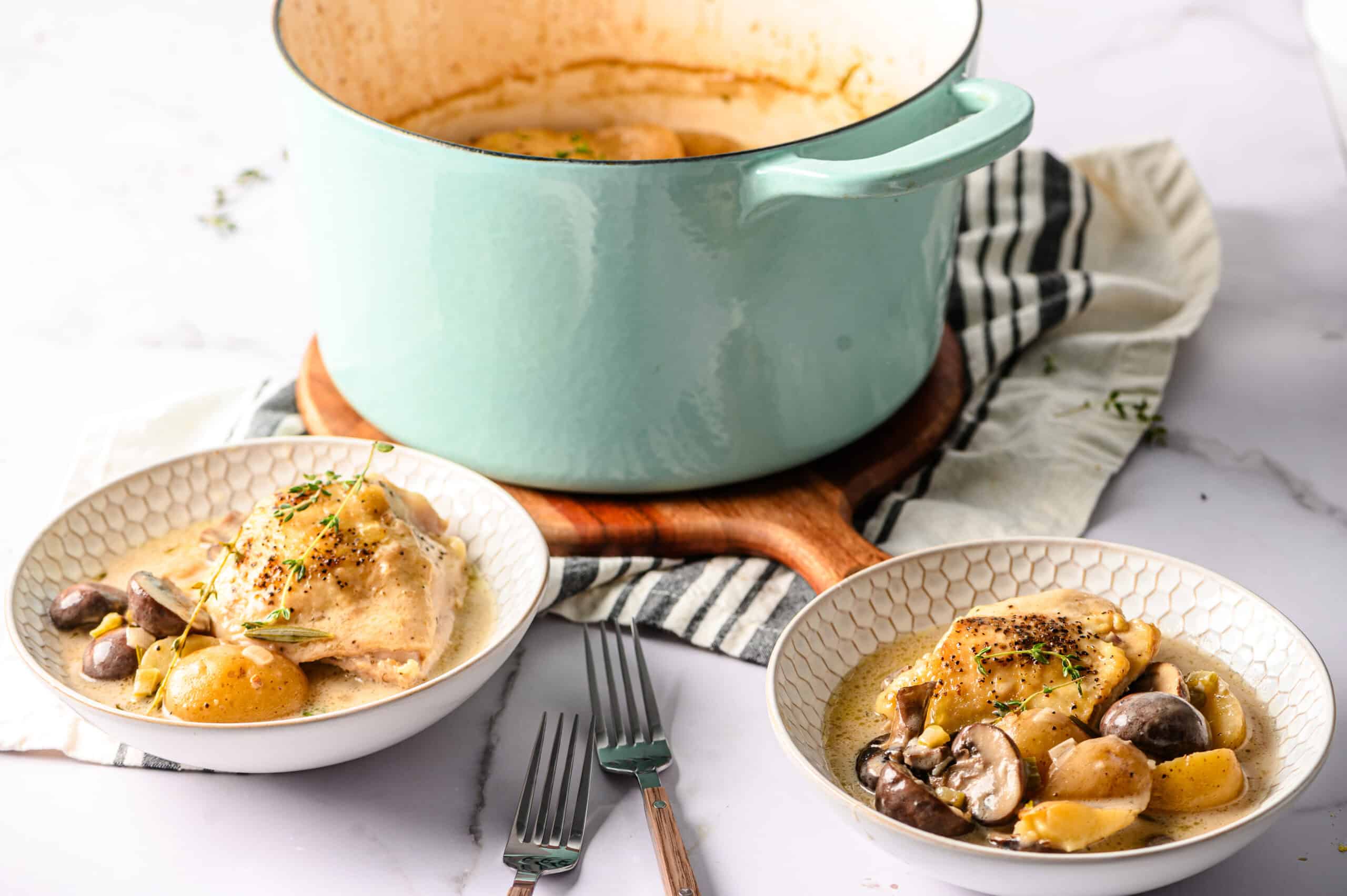 Creamy chicken and mushroom stew served with tender chicken, fresh mushrooms, and potatoes in a flavorful broth, garnished with herbs, in a cozy kitchen setting.