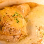 Juicy chicken thighs cooked in a creamy, flavorful sauce garnished with fresh thyme and herbs, perfect for comforting homemade dinner recipes.
